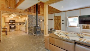 Una cabaña espaciosa con chimenea de piedra, interior de madera y una zona de estar acogedora.