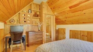 Una habitación con paneles de madera, una cama, un escritorio y un aparador.