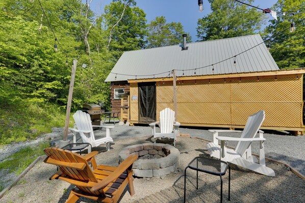 A cabin with a fire pit, outdoor seating, and a wooden deck. - Private Cabin Rental in the Catskill Mountains! (Hamden)