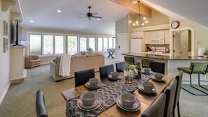 A spacious living area with a dining table set for six, a sofa, and a kitchen in the background. - Jackson Lakefront Getaway w/ Balcony, Dock Access (Jackson)