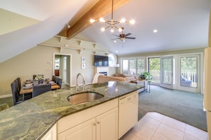 A spacious kitchen with a granite countertop, a ceiling fan, and a dining area with a table and chairs. - Jackson Lakefront Getaway w/ Balcony, Dock Access (Jackson)