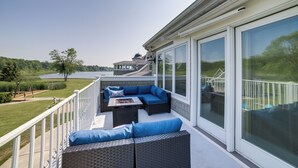 A covered outdoor seating area with a view of a lake and a house in the background. - Jackson Lakefront Getaway w/ Balcony, Dock Access (Jackson)