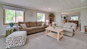 A spacious living room with two sofas, a coffee table, and a side table with a plant. - Northern Michigan Vacation Rental Near Trails! (Atlanta)