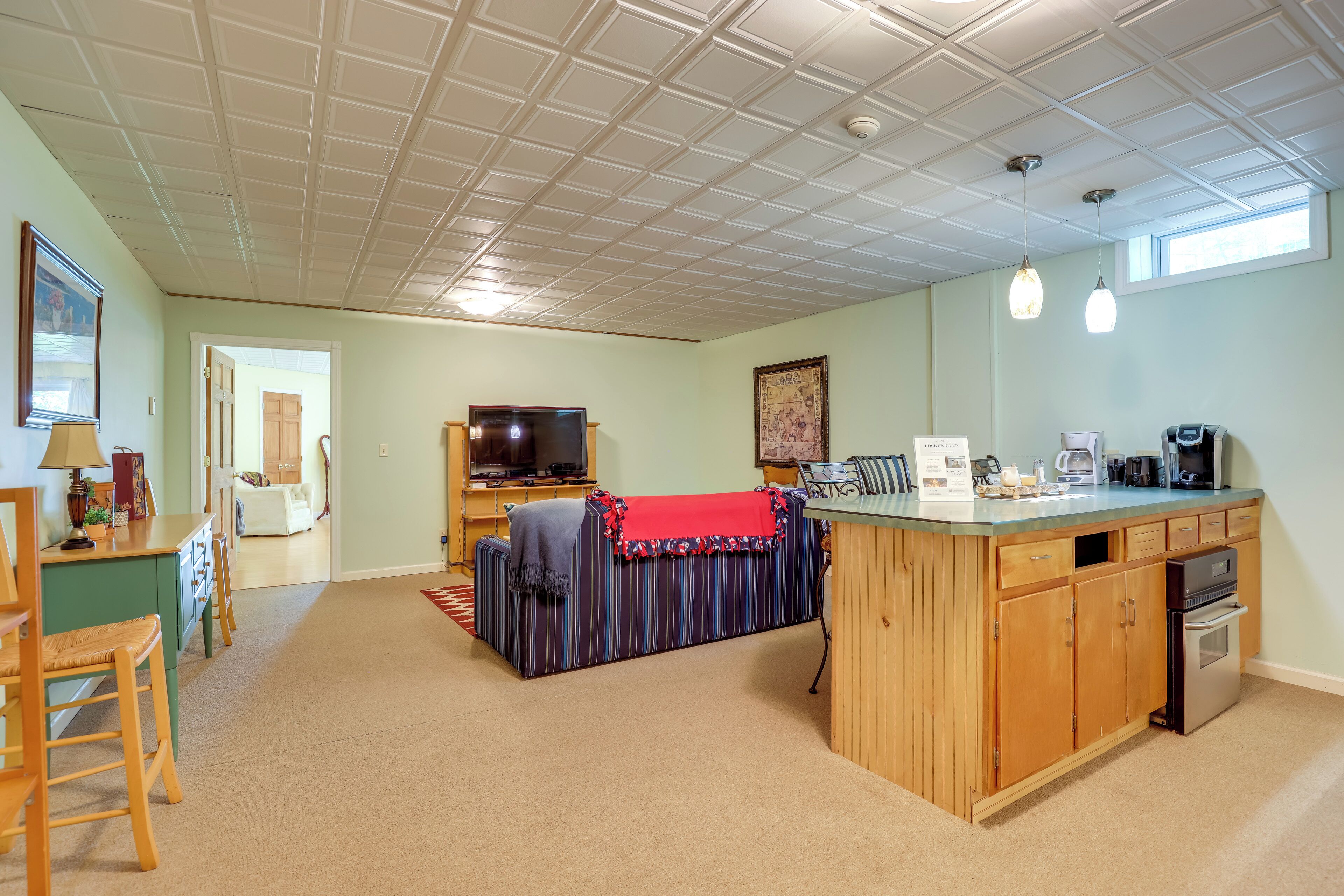 A spacious living area with a kitchen island, a television, and a dining area.