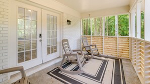 A covered porch with rocking chairs, a wooden bench, and a rug. - Northport Game Day Getaway: 5 Mi to University! (Northport)