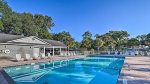 A swimming pool with lounge chairs, a covered seating area, and a building labeled "HICKORY POOL".
