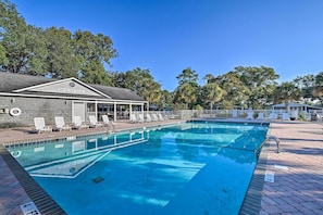 A swimming pool with lounge chairs, a covered seating area, and a building labeled "HICKORY POOL".