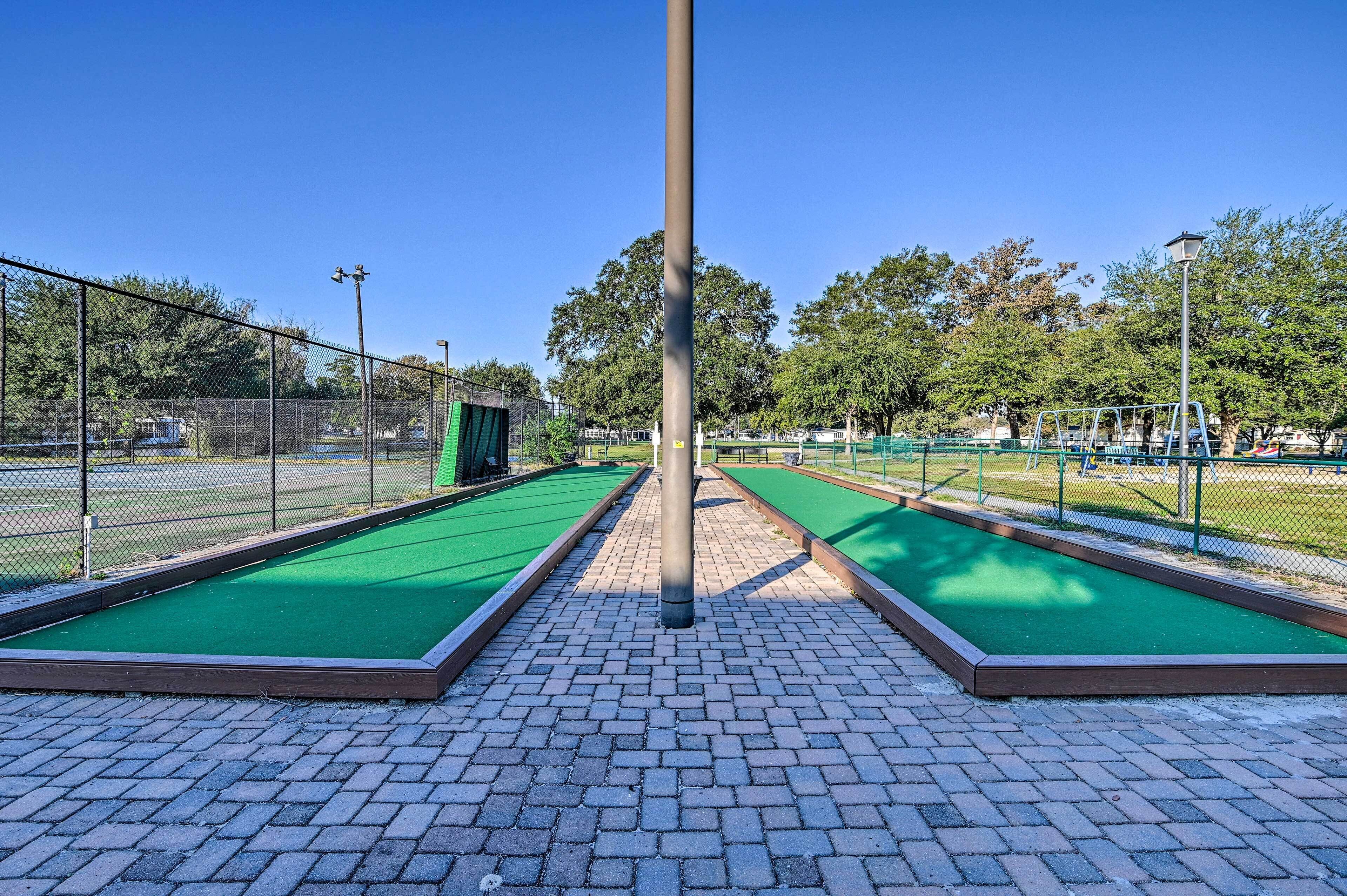 A bowling alley with green lanes and a brick-paved walkway.