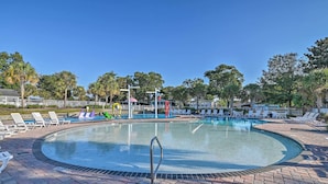 A circular pool with lounge chairs and a lifeguard stand.