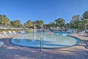 A circular pool with lounge chairs and a lifeguard stand.