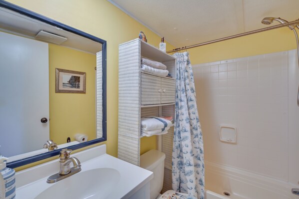 A bathroom with a sink, mirror, toilet, and shower curtain. - Walk to Shore: Myrtle Beach House w/ Private Deck! (Murrells Inlet)
