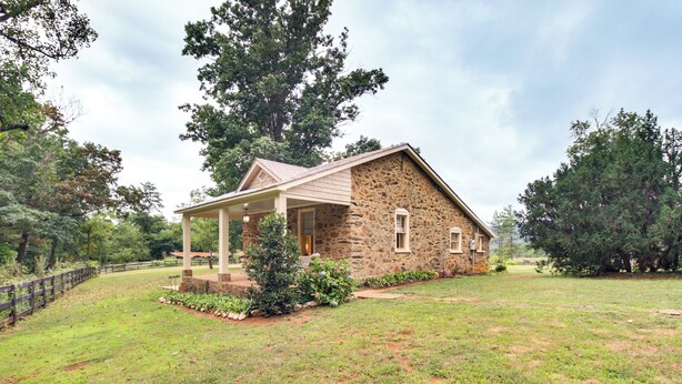 A stone house with a covered porch and a grassy yard. - Monticello Wine Trail Cottage - Close to Hiking! (Afton)