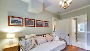 A bedroom with a bed, nightstand, lamp, and framed pictures on the wall. - Monticello Wine Trail Cottage - Close to Hiking! (Afton)