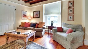 A living room with a wooden coffee table, two sofas, a rug, and framed pictures on the wall. - Monticello Wine Trail Cottage - Close to Hiking! (Afton)