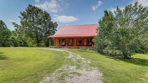 A two-story house with a red roof, surrounded by a well-maintained lawn and trees. - Secluded Harrison Retreat Near Buffalo Natl River (Harrison)