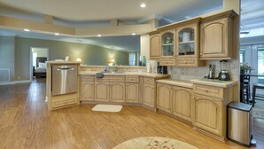 A spacious kitchen with wooden cabinets, a stainless steel refrigerator, and a large island. - Waterfront Georgetown Retreat on Lake George! (Georgetown)