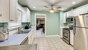 A kitchen with white cabinets, a stainless steel refrigerator, a microwave, and a stove.