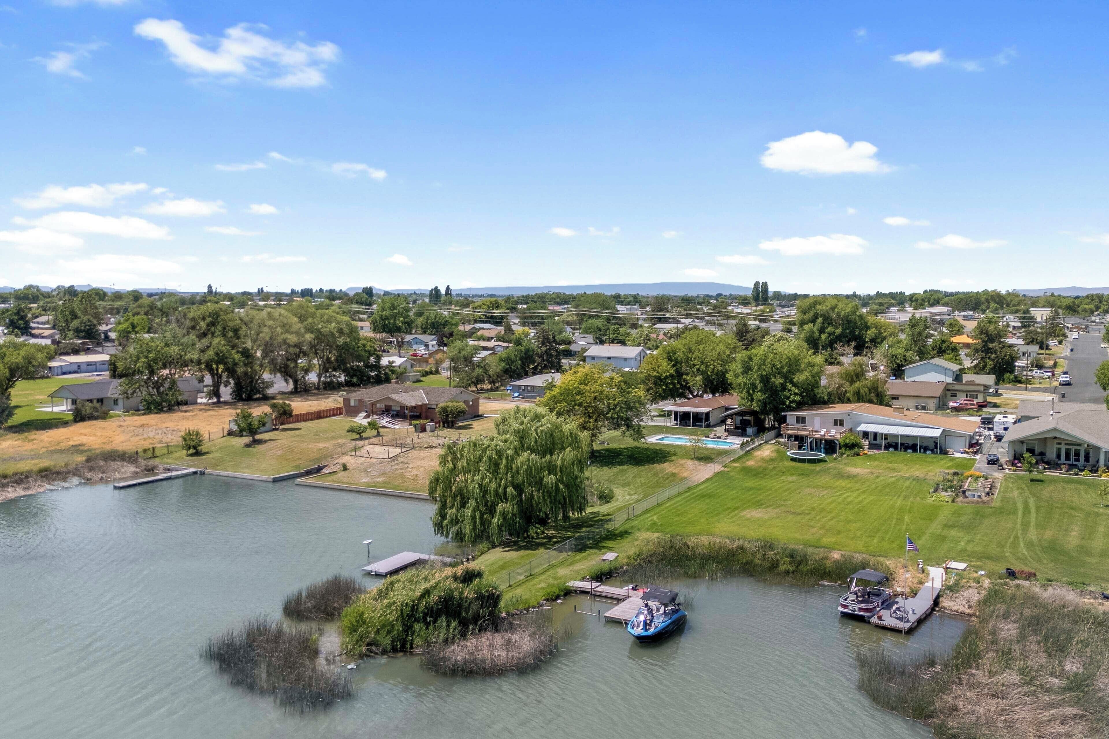 Un quartier résidentiel avec des maisons, un lac et des bateaux amarrés à un quai.