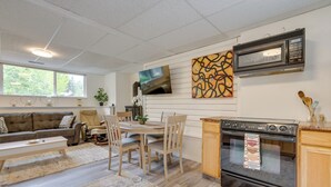 Et moderne køkken med en stor komfur, en mikrobølgeovn og et spiseområde med et bord og stole.
