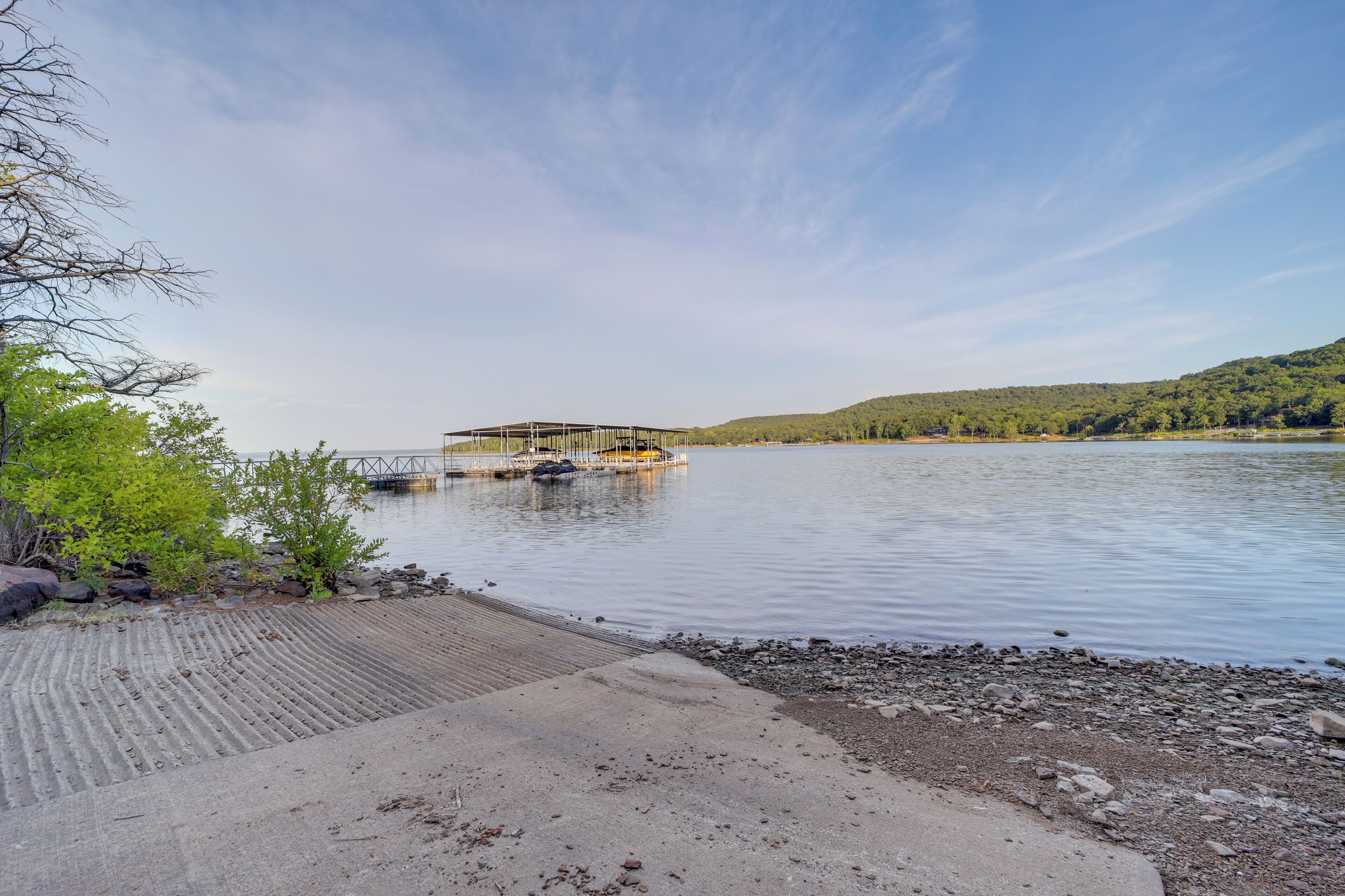 Une vue sur le lac, avec un quai, une eau calme et un paysage vallonné.