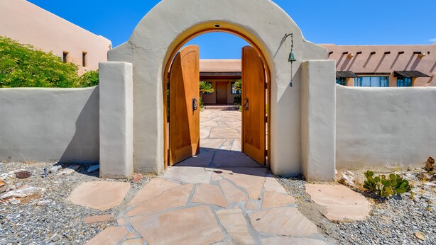 An arched entrance with a stone pathway leading to a building with a stucco exterior. - Chic Borrego Springs Home w/ Outdoor Oasis! (Borrego Springs)