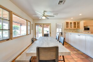 A spacious kitchen with a large dining table, wooden cabinets, and a ceiling fan. - Chic Borrego Springs Home w/ Outdoor Oasis! (Borrego Springs)