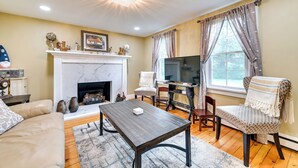 Una sala de estar con chimenea, televisor y mesa de comedor.