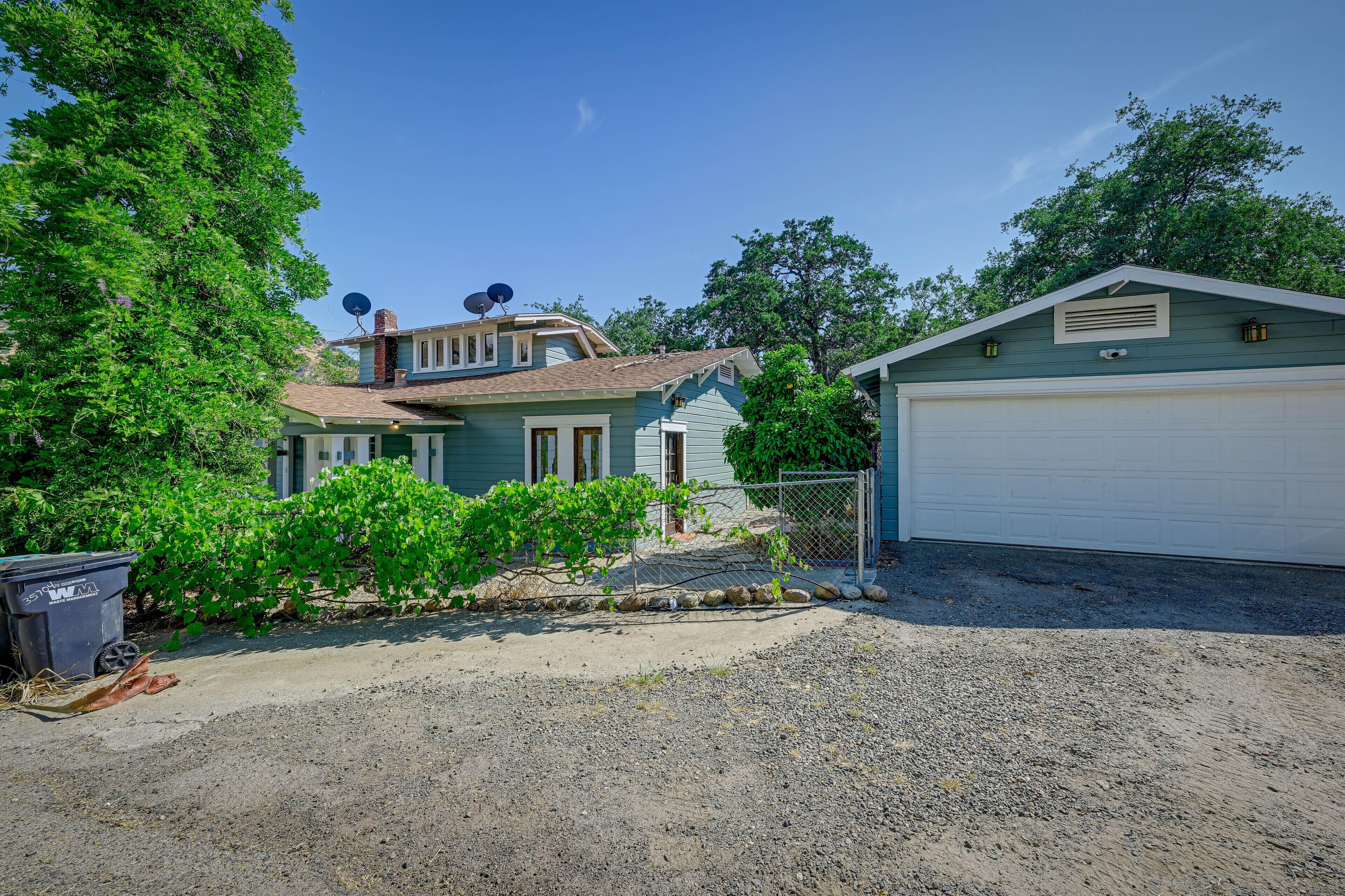 A residential property with a detached house, a garage, and a fenced garden area.
