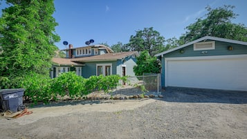 A residential property with a detached house, a garage, and a fenced garden area.