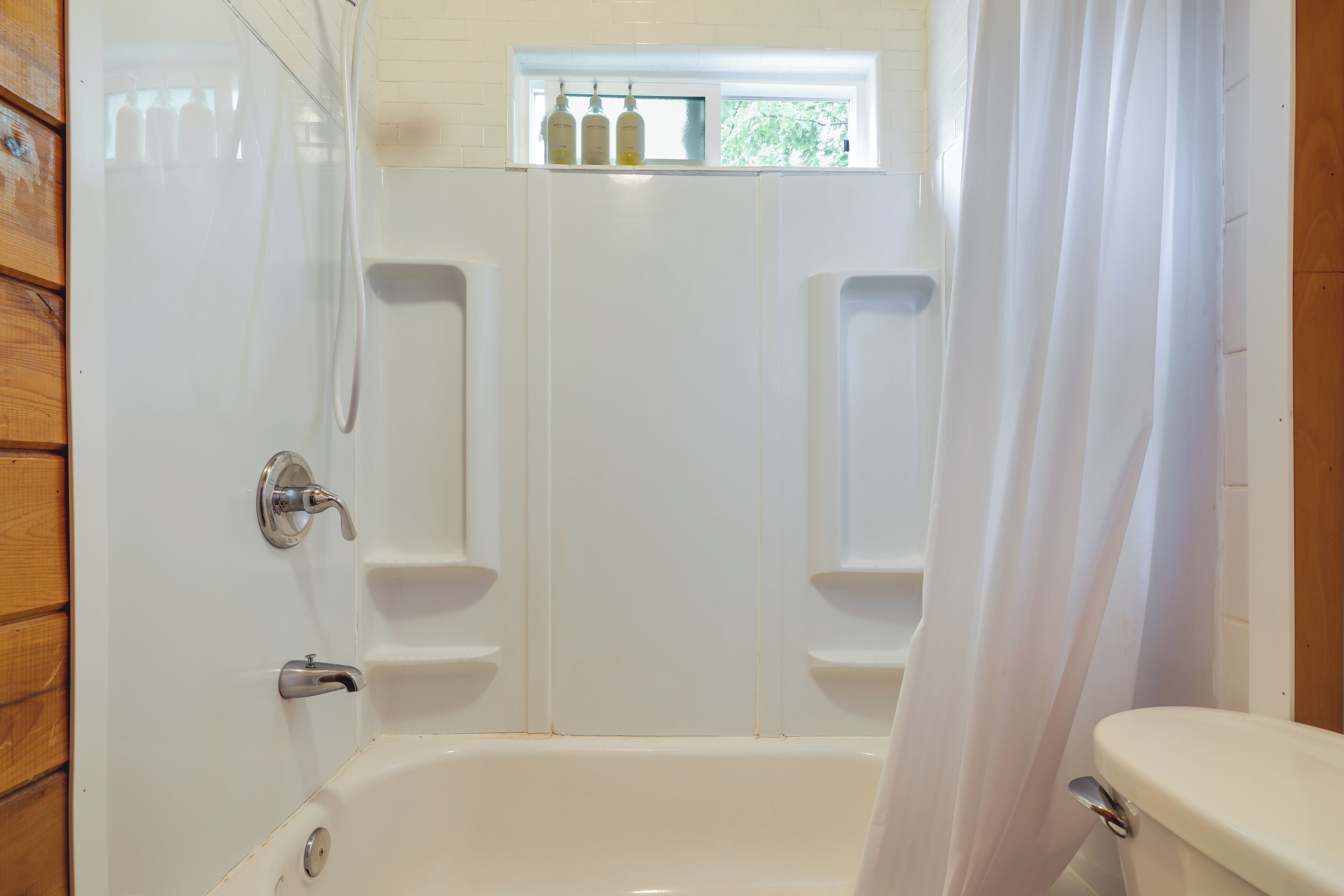Une salle de bain avec une baignoire, des toilettes et un rideau de douche.