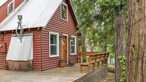 A rustic log cabin with a wooden deck, a front door, and a bench. - Fire Pit, Deck & Grill: Cozy Twain Harte Cabin! (Twain Harte)
