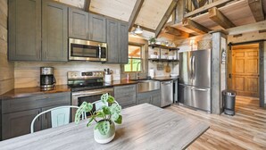 Una cocina moderna con electrodomésticos de acero inoxidable, armarios de madera y una mesa de comedor con una planta en maceta.