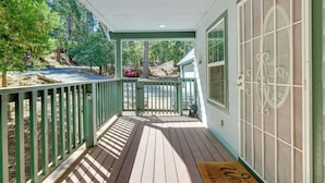 A covered porch with a wooden deck, a green railing, and a door with a decorative glass panel. - Near Dtwn: Twain Harte Home w/ Furnished Deck! (Twain Harte)