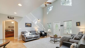 A spacious living room with a staircase, a fireplace, and a dining area with a glass table. - Near Dtwn: Twain Harte Home w/ Furnished Deck! (Twain Harte)
