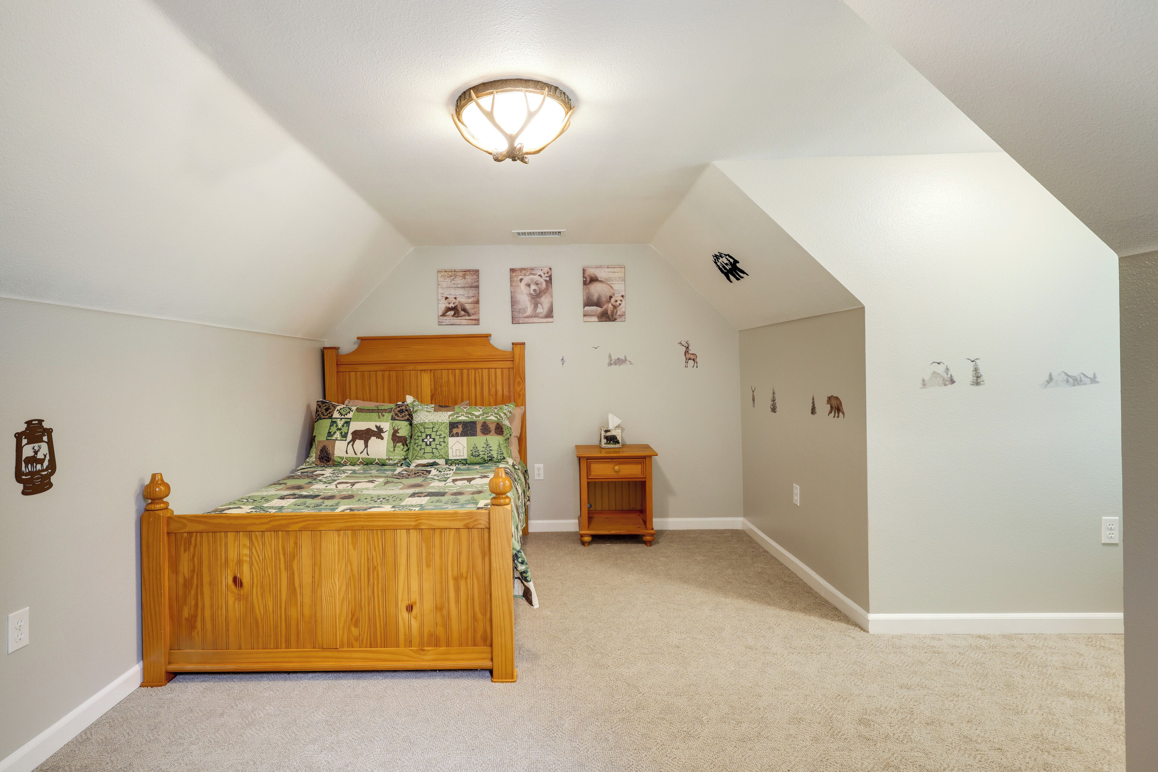 A bedroom with a wooden bed, a nightstand, and wall decorations including animal prints.
