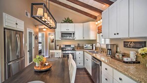 A modern kitchen with white cabinets, stainless steel appliances, and a granite countertop. - Tree-lined Twin Peaks Cottage w/ Custom Stream (Lake Arrowhead)
