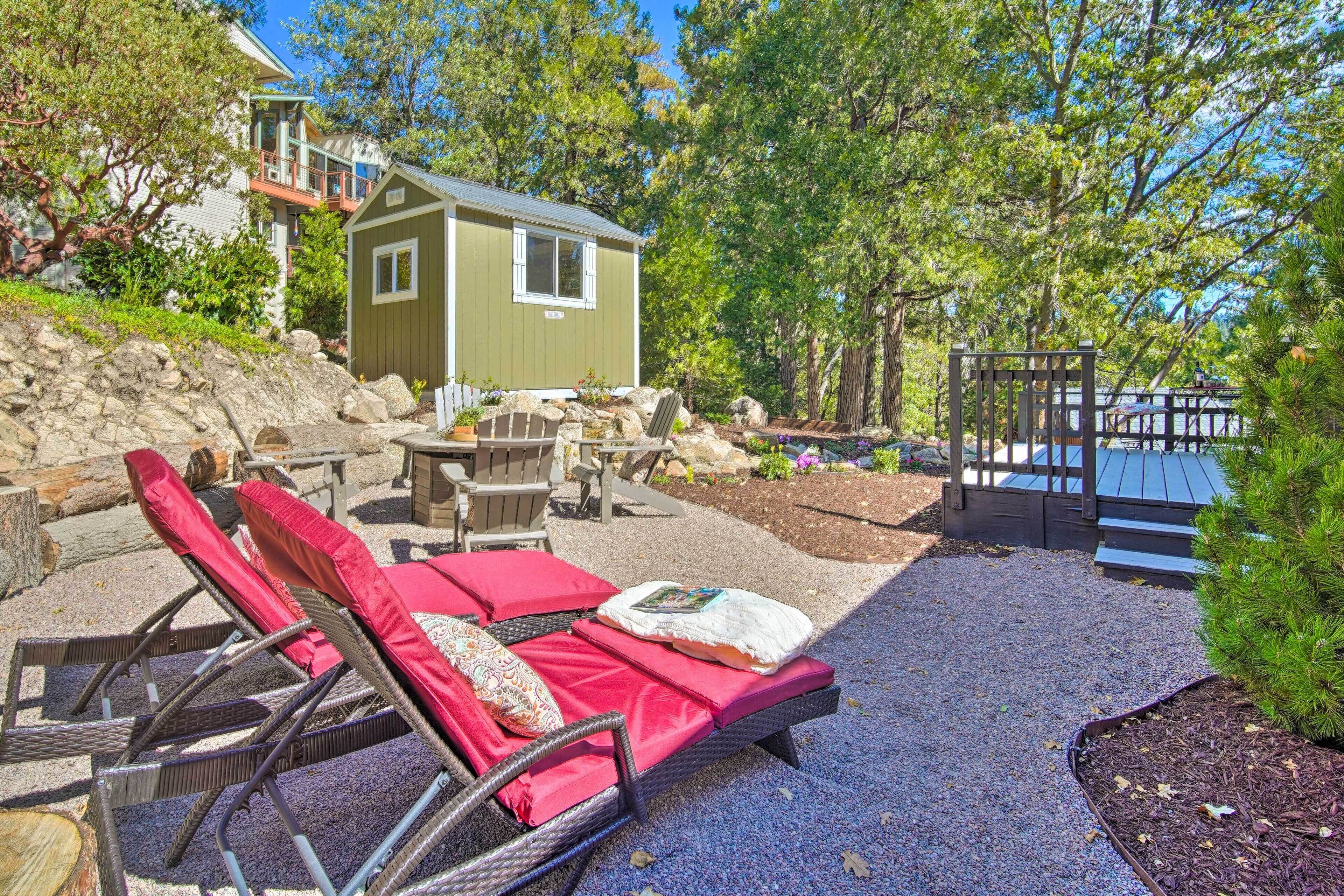 A backyard with a covered seating area, a small shed, and a wooden deck.