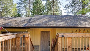 A wooden cabin with a stone foundation, a wooden door, and a welcome sign. - Cozy Mi-wuk Village Cabin w/ Deck! (Mi-Wuk Village)