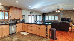A spacious kitchen with wooden cabinets, a dishwasher, and a stone tile floor. - Cozy Mi-wuk Village Cabin w/ Deck! (Mi-Wuk Village)