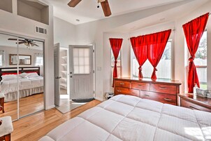 Un dormitorio con una cama grande, un aparador de madera, un espejo y cortinas rojas.