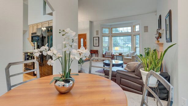 A spacious living room with a dining area, large windows, and a view of the kitchen. - Family-friendly Hot Tub Home in Bonney Lake (Bonney Lake)