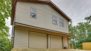 A two-story house with a garage, a front porch, and a wooden fence.