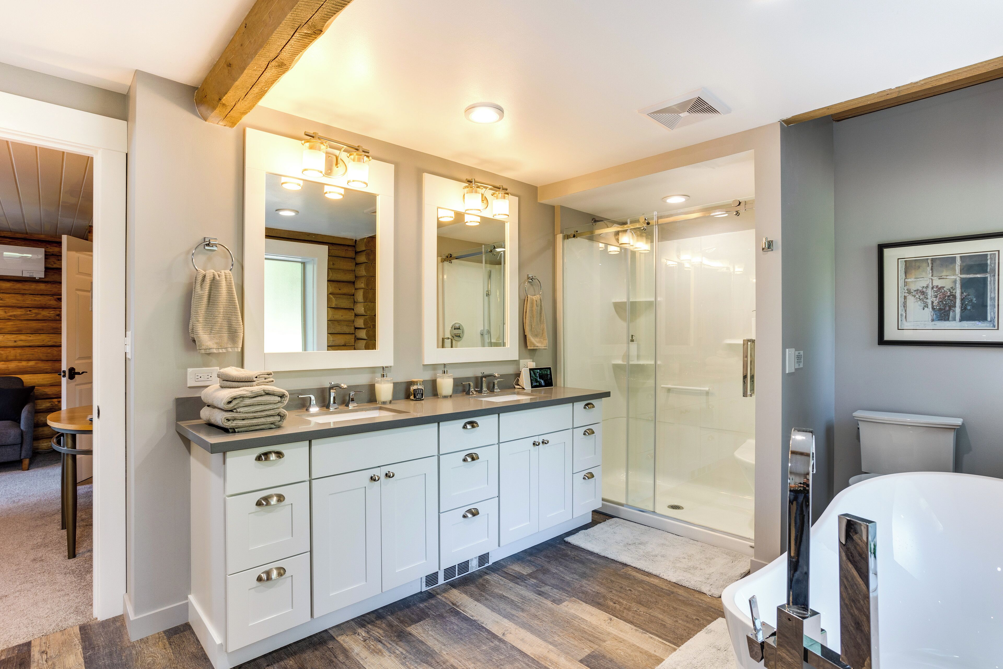 A modern bathroom with a large vanity, a walk-in shower, and a toilet.