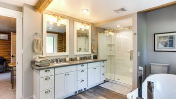 A modern bathroom with a large vanity, a walk-in shower, and a toilet.