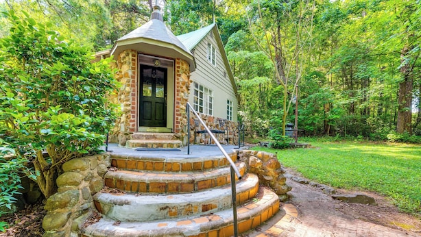 A stone staircase leading to a house with a green door, surrounded by lush greenery. - Salisbury Cottage ~ 7 Mi to High Rock Lake! (Salisbury)