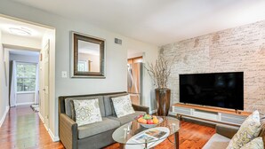 Ein Wohnzimmer mit einer Couch, einem Couchtisch und einem Fernseher.