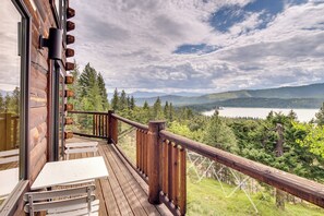A wooden deck with a table and chairs, overlooking a lake and forested mountains. - Luxury Mtn Cabin w/ Sweeping Cle Elum Lake Views! (Cle Elum)