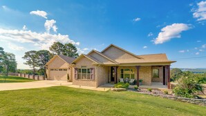 A two-story house with a garage, a front porch, and a well-maintained lawn. - Russellville Home Near Hiking + Lake Access! (Russellville)