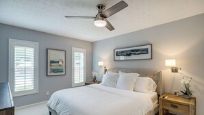 A bedroom with a bed, nightstands, a ceiling fan, and artwork on the walls. - Ponte Vedra Beach Vacation Rental w/ Private Pool! (Ponte Vedra Beach)