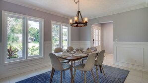A dining area with a round table, six chairs, and a chandelier. - Ponte Vedra Beach Vacation Rental w/ Private Pool! (Ponte Vedra Beach)